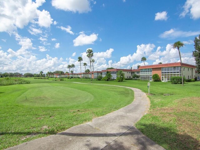 surrounding community featuring view of golf course and a lawn