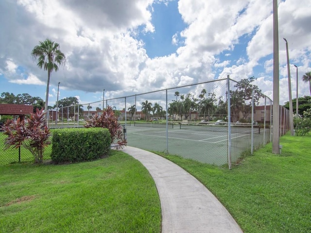 view of sport court featuring fence and a yard