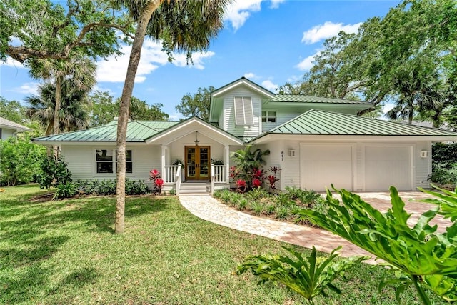 view of front of home featuring a standing seam roof, a garage, french doors, and metal roof