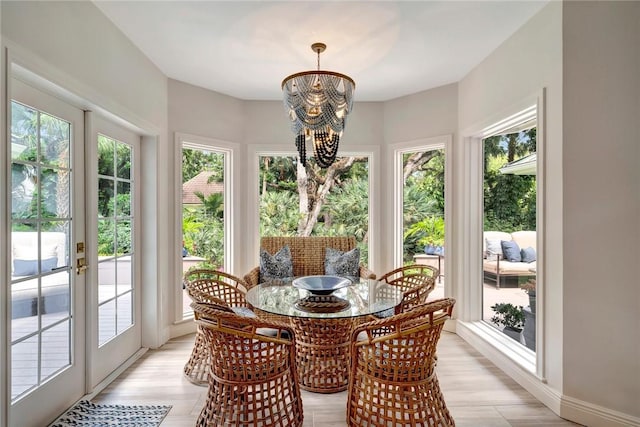 sunroom / solarium featuring an inviting chandelier and french doors