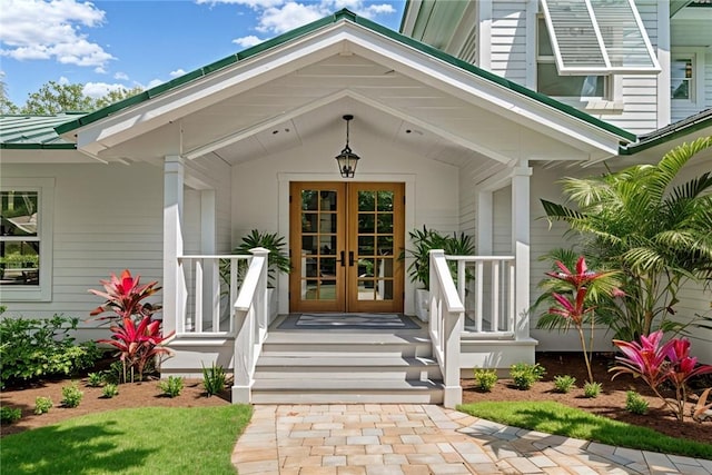 view of exterior entry with french doors and a porch
