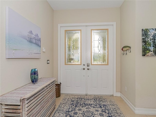 doorway with french doors, baseboards, and light tile patterned floors