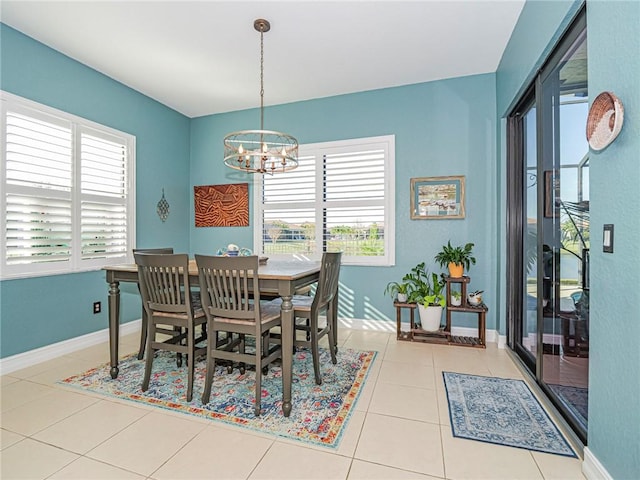 dining space featuring a notable chandelier, baseboards, and light tile patterned floors