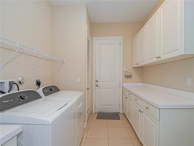 laundry area with cabinet space, washer and dryer, and light tile patterned flooring