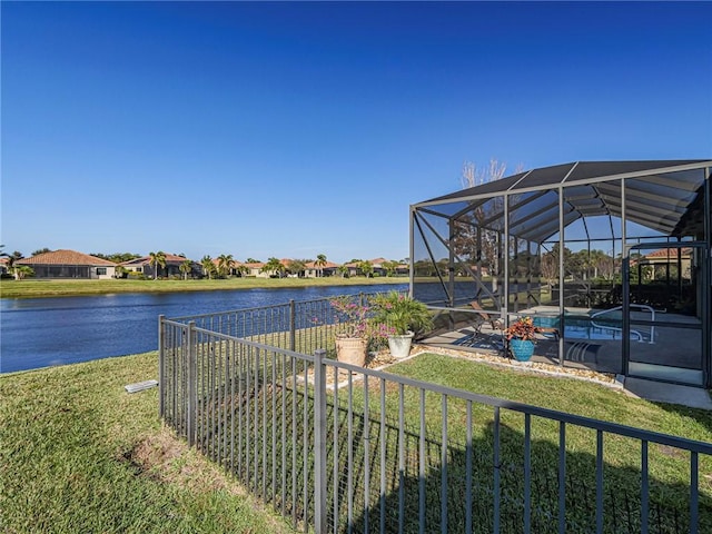 exterior space with an outdoor pool, glass enclosure, and a water view