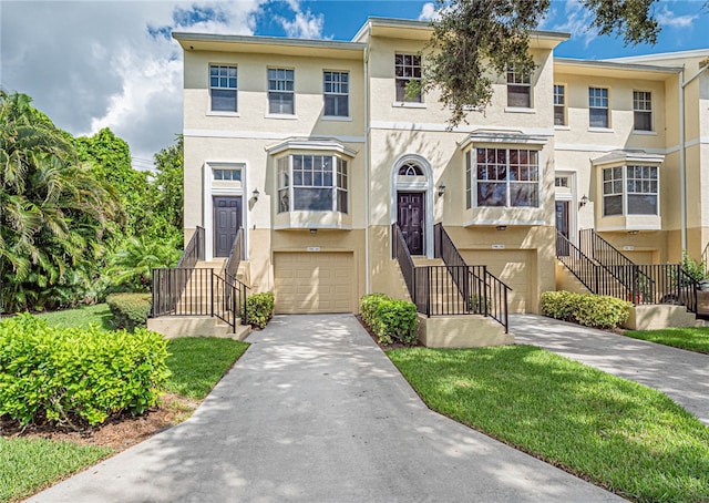 townhome / multi-family property featuring a front lawn and a garage