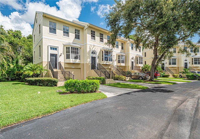 townhome / multi-family property with a front yard