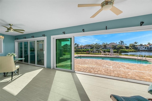 doorway to outside with a water view, a healthy amount of sunlight, and ceiling fan