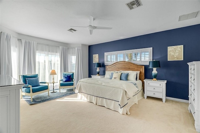 bedroom with ceiling fan, multiple windows, and light carpet