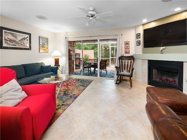 tiled living room featuring ceiling fan and a tile fireplace