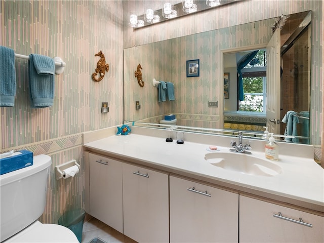 bathroom with tile patterned flooring, vanity, and toilet