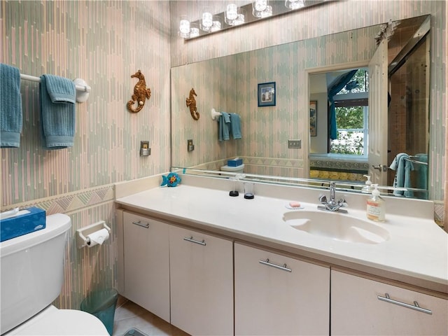 1308 Coral Park Ln Unit 104, Vero Beach, FL 32963 - bathroom featuring wallpapered walls, vanity, and toilet