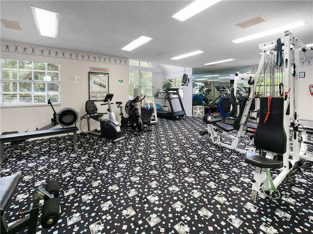 gym featuring a textured ceiling and a healthy amount of sunlight