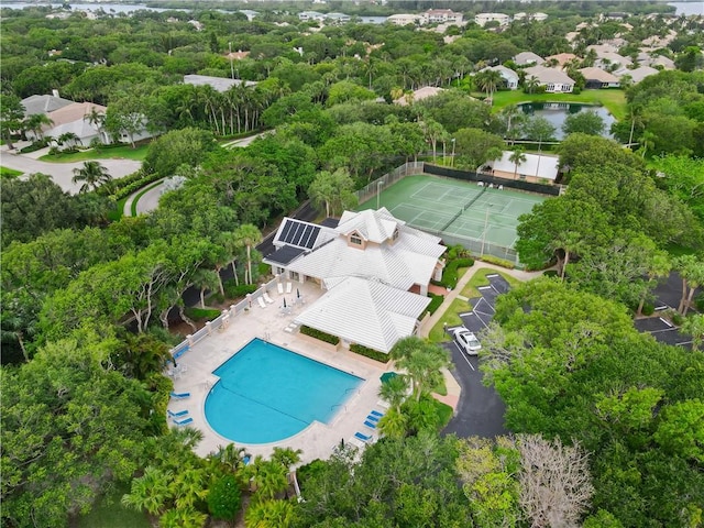 1308 Coral Park Ln Unit 104, Vero Beach, FL 32963 - bird's eye view of a pool, a large body of water, and a tree filled landscape