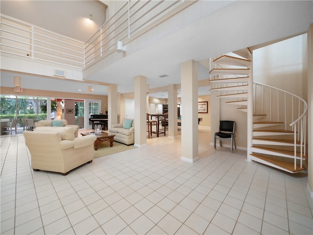 living room featuring light tile patterned floors and a high ceiling