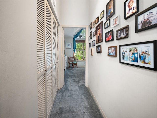 hall with dark colored carpet