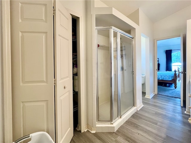 bathroom featuring hardwood / wood-style flooring and a shower with door