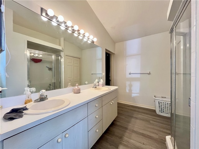 bathroom featuring hardwood / wood-style floors, vanity, a shower with shower door, and lofted ceiling