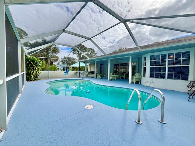 view of swimming pool featuring a patio and glass enclosure