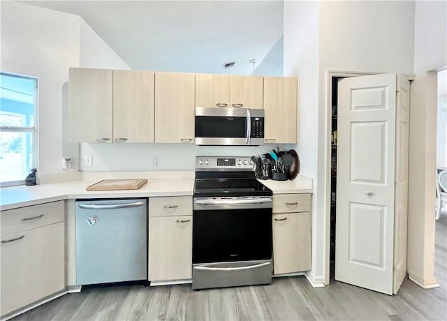 kitchen featuring light brown cabinets, stainless steel appliances, and light hardwood / wood-style flooring