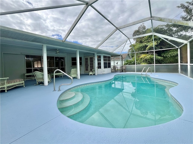 view of pool with ceiling fan, a lanai, and a patio