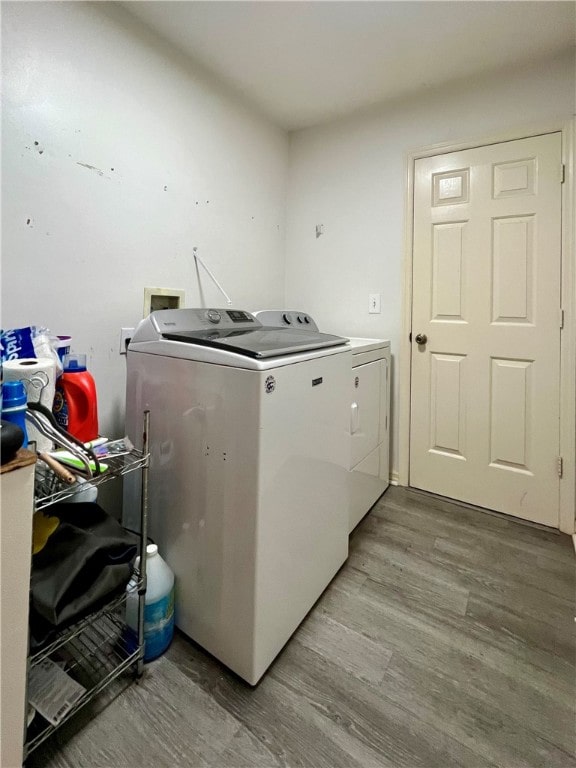 laundry area featuring light hardwood / wood-style flooring and washing machine and clothes dryer