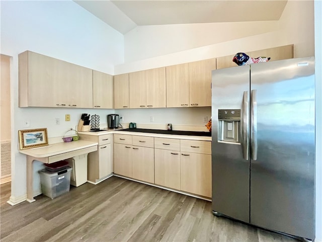 kitchen with stainless steel fridge, light brown cabinetry, light hardwood / wood-style floors, and lofted ceiling