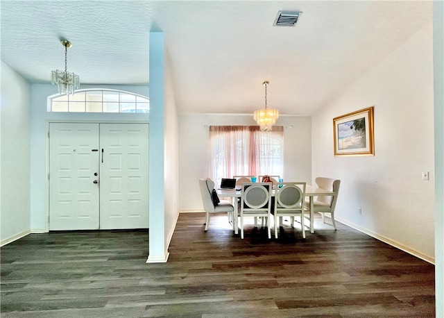 dining area with dark hardwood / wood-style floors and an inviting chandelier