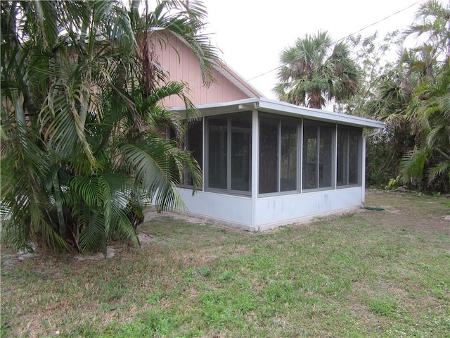 view of property exterior with a yard and a sunroom