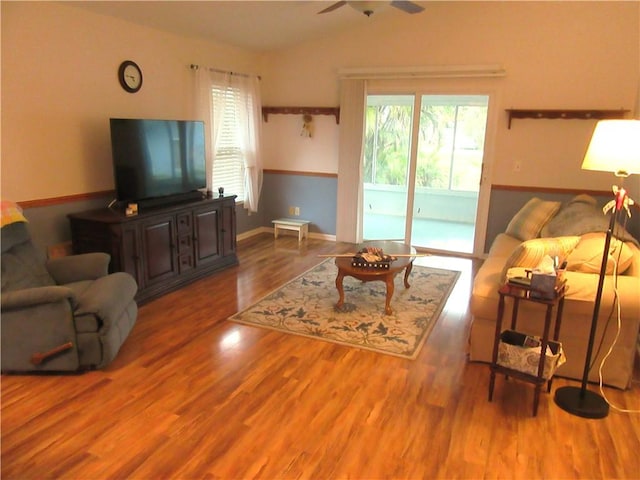 living room with ceiling fan, lofted ceiling, and wood finished floors