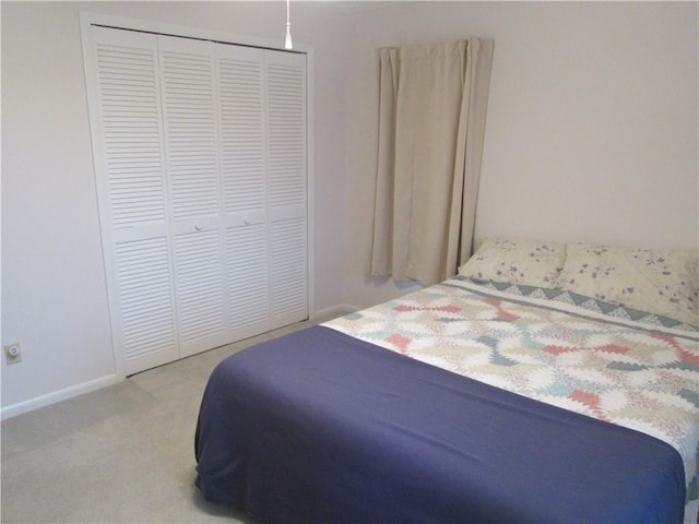 carpeted bedroom featuring baseboards and a closet