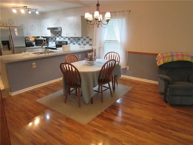 dining room with an inviting chandelier, wood finished floors, and baseboards