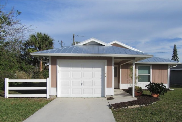 view of front of house with metal roof, concrete driveway, an attached garage, and fence