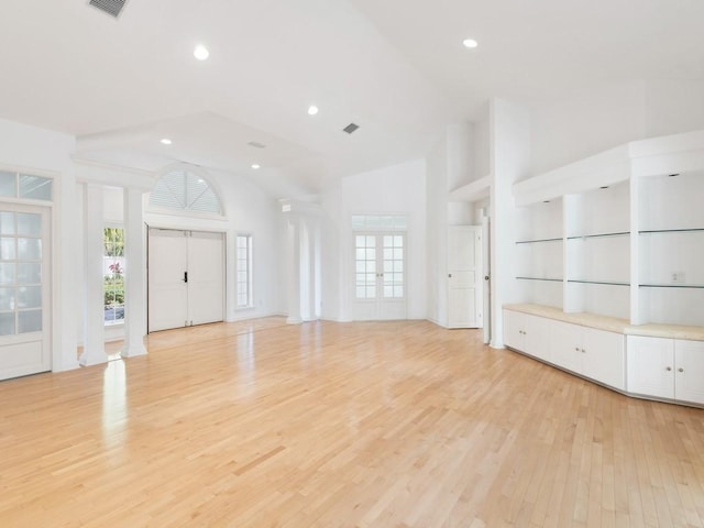 unfurnished living room featuring high vaulted ceiling, light wood-type flooring, and recessed lighting