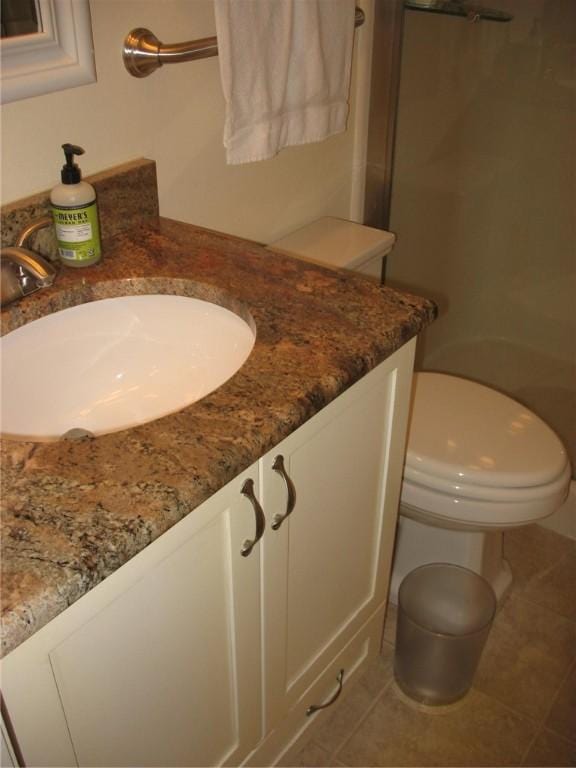 bathroom featuring tile patterned flooring, vanity, and toilet