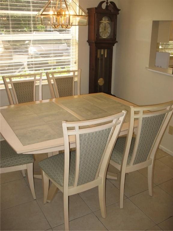 dining room with tile patterned floors and a notable chandelier