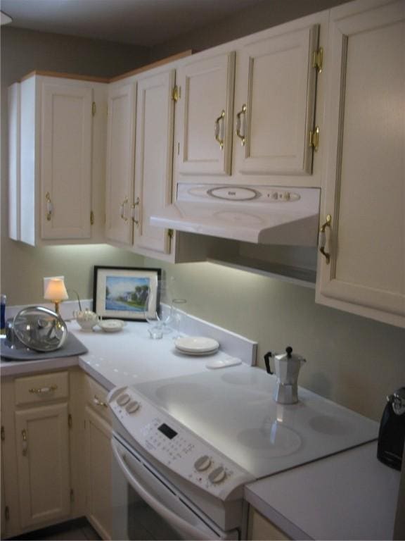 kitchen featuring white range with electric cooktop and white cabinetry