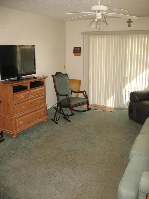 carpeted living room with ceiling fan and a textured ceiling