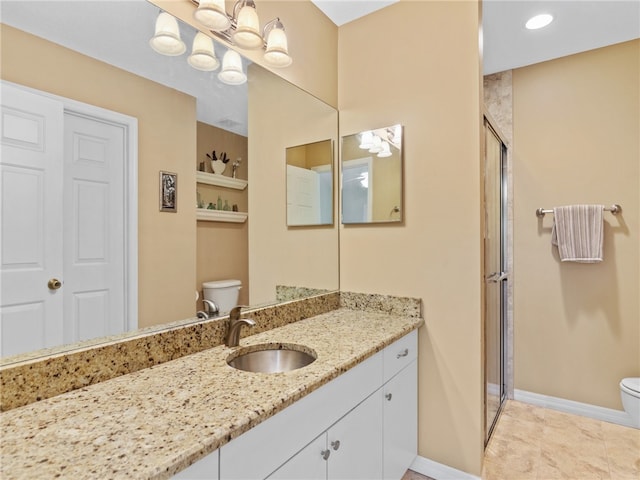 bathroom featuring tile patterned floors, a shower with door, vanity, and toilet