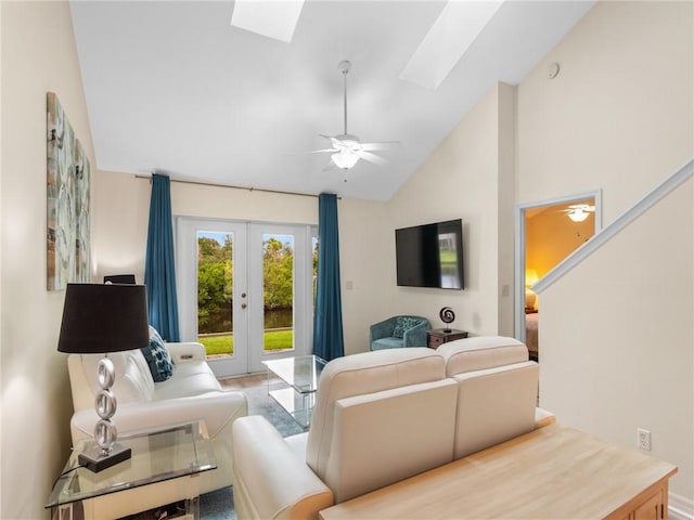 living room with ceiling fan, french doors, high vaulted ceiling, and a skylight