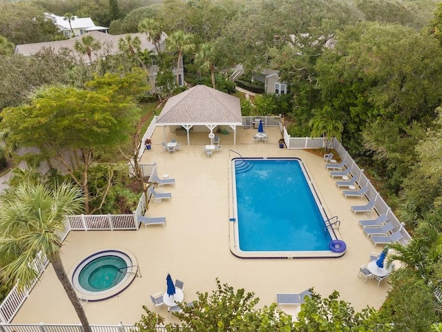 view of swimming pool featuring a patio and a hot tub