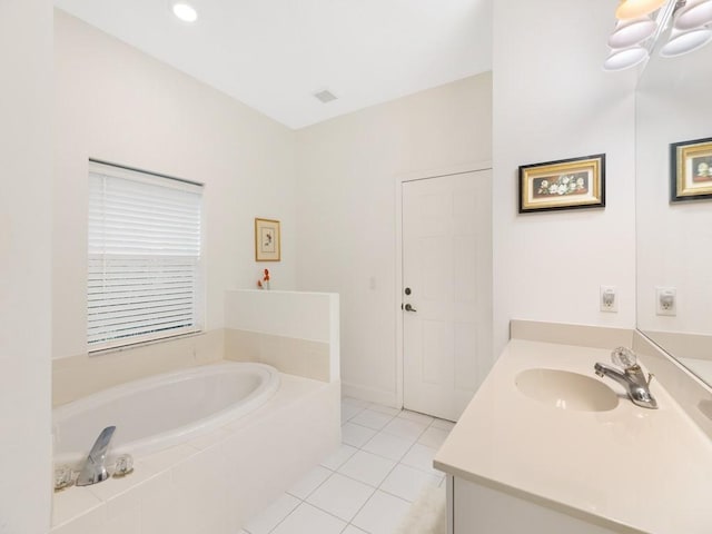 bathroom featuring tile patterned floors, vanity, and tiled bath