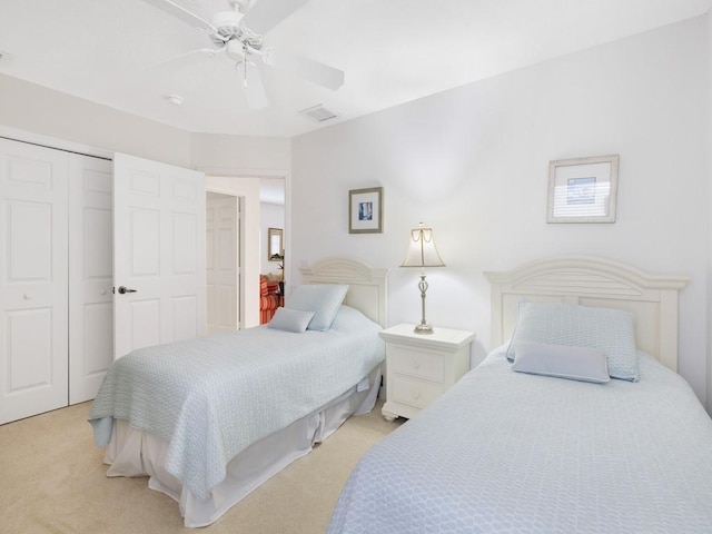 carpeted bedroom featuring ceiling fan and a closet