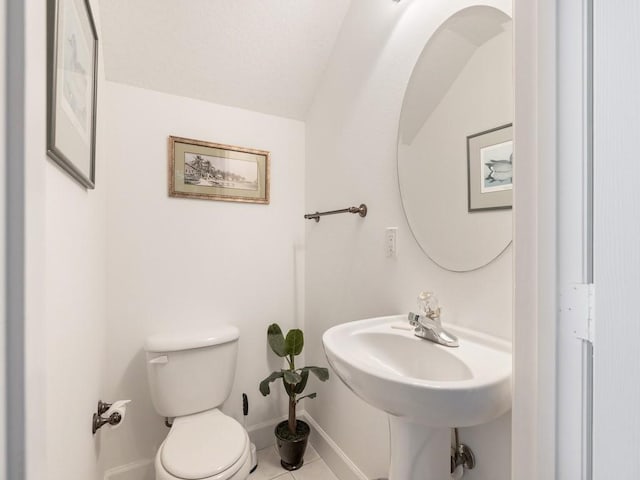 bathroom featuring tile patterned flooring, lofted ceiling, and toilet