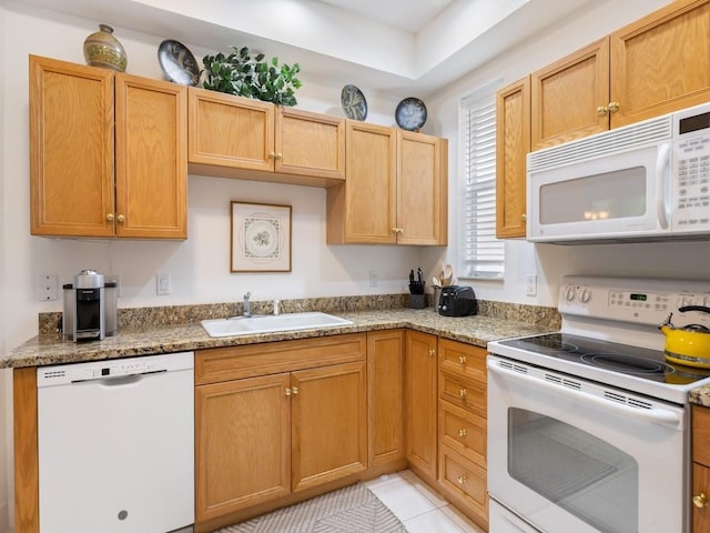 kitchen featuring light stone countertops, white appliances, light tile patterned flooring, and sink