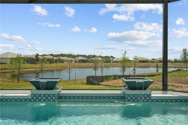 view of pool with a water view and a lawn