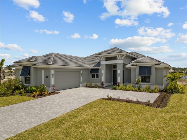 prairie-style home featuring a front lawn and a garage