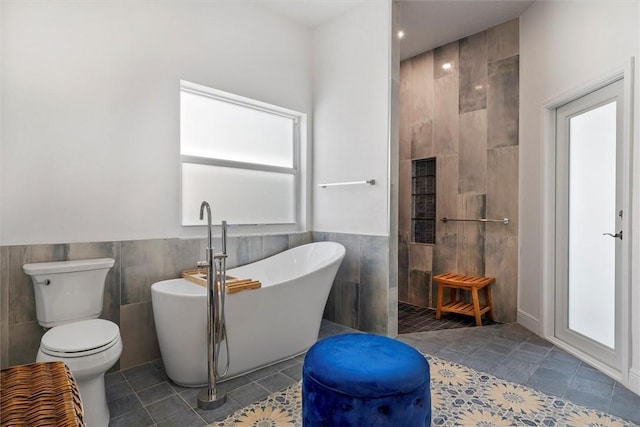 3612 2nd St SW, Vero Beach, FL 32968 - full bath with tile walls, a soaking tub, walk in shower, wainscoting, and tile patterned floors