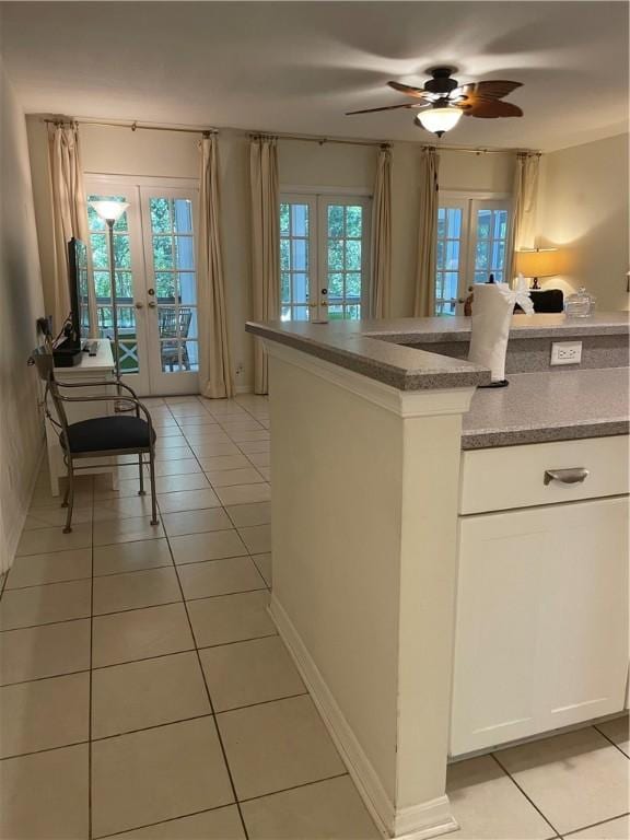 1275 Winding Oaks Cir E Unit 702, Vero Beach, FL 32963 - kitchen featuring french doors, light tile patterned floors, ceiling fan, and white cabinetry
