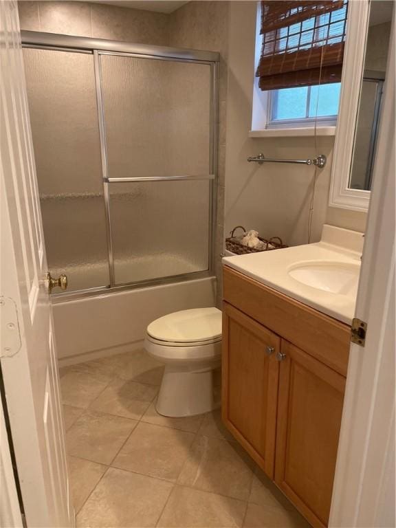 1275 Winding Oaks Cir E Unit 702, Vero Beach, FL 32963 - bathroom with vanity, toilet, tile patterned flooring, and shower / bath combination with glass door